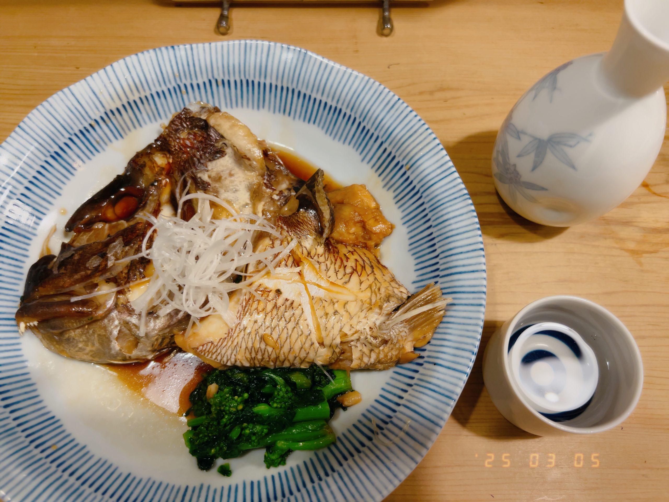 真鯛の頭を甘辛く煮付けた煮魚と熱燗(種類は忘れてしまった)