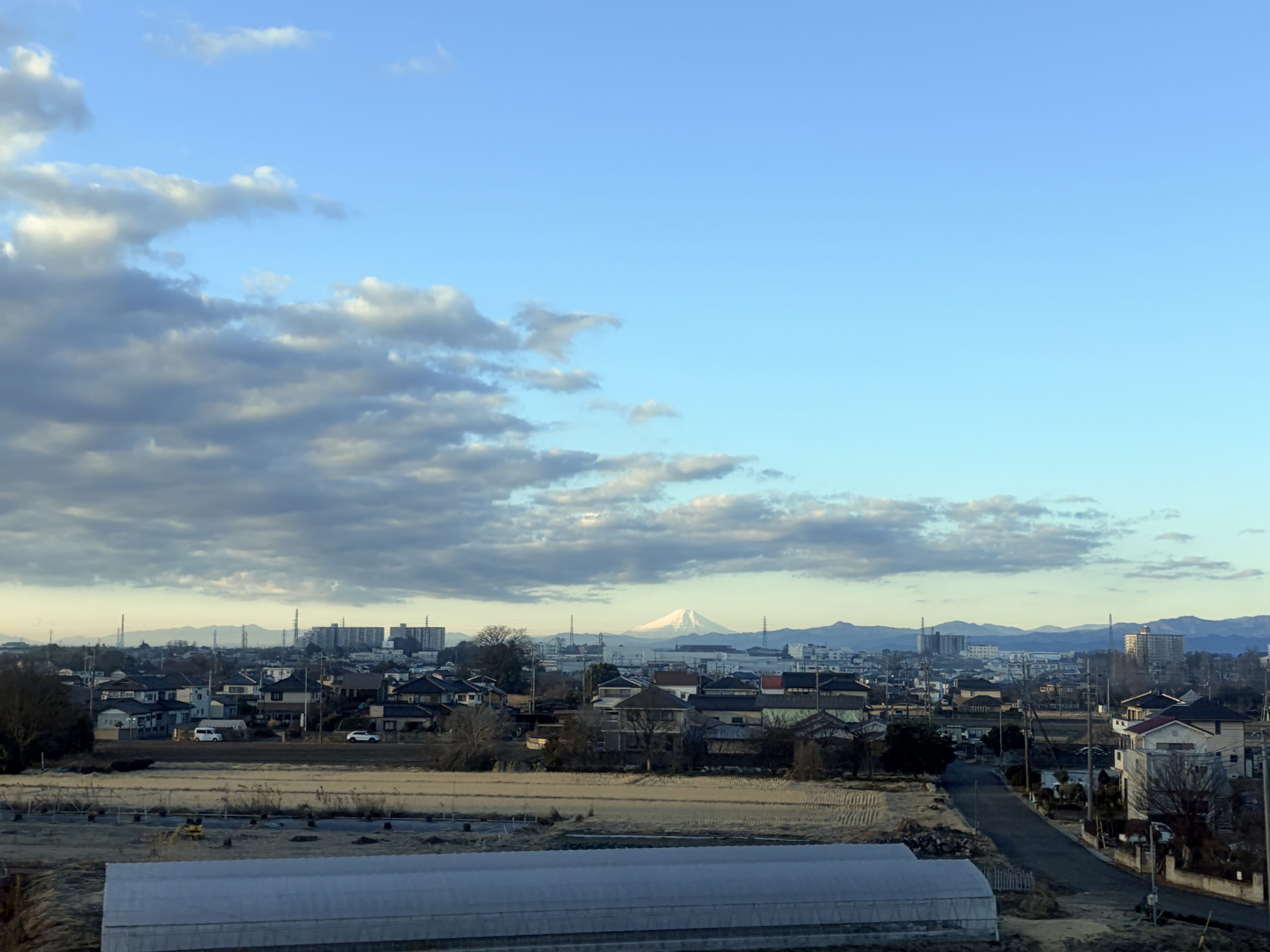 東京から高崎へ向かう新幹線の車窓。左手の遠景に、冬の空にくっきりと浮かぶ富士山が見えた。
