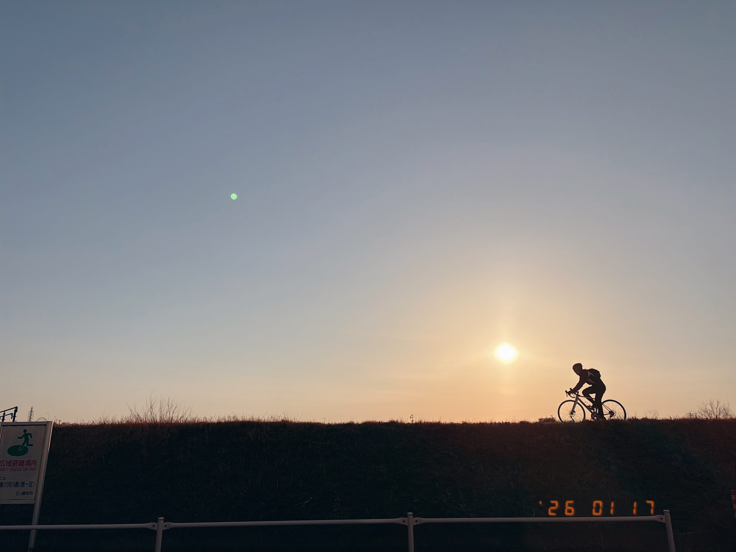 川沿いを走る自転車のシルエットの写真